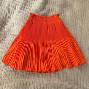 Orange pleated mini circle skirt